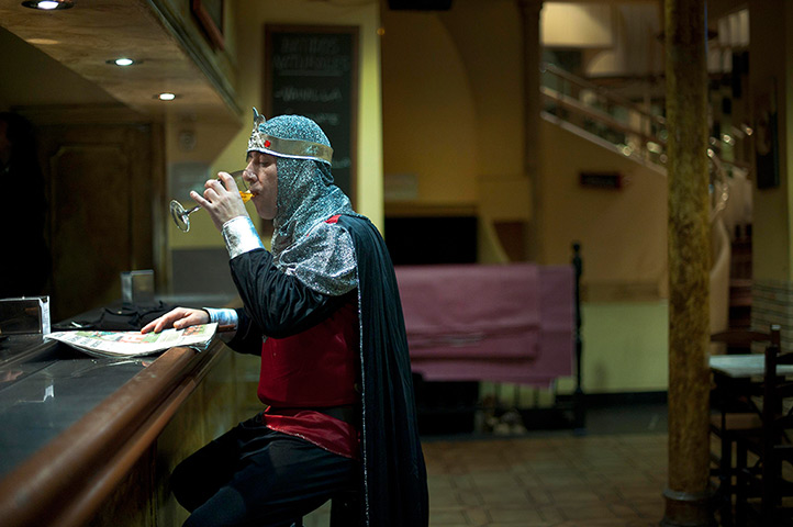 24 hours: Bilbao, Spain: A man wearing a medieval costume has a drink during carnival