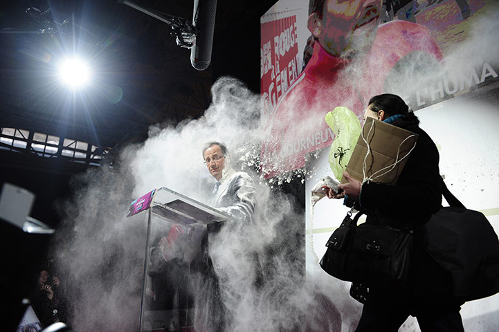 24 hours in pictures: Paris, France: A woman throws flour on Francois Hollande