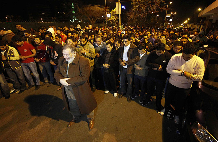 Port Said clashes: People pray near Port Said stadium at Ramses metro station in Cairo