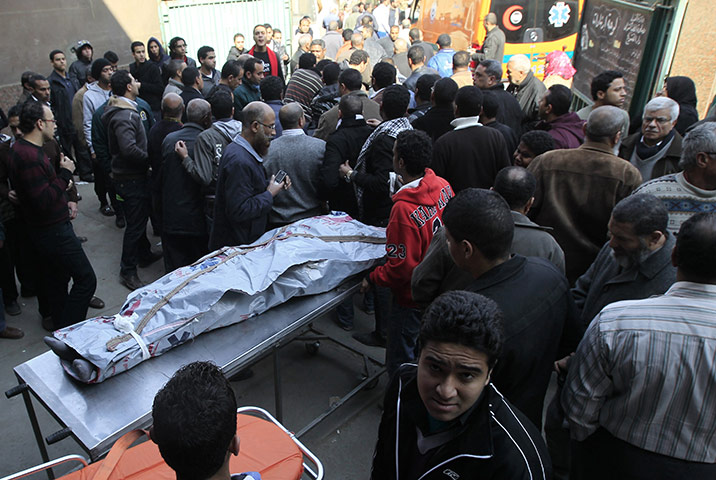 Port Said clashes: Egyptians stand around the body of a victim of football violence, egypt