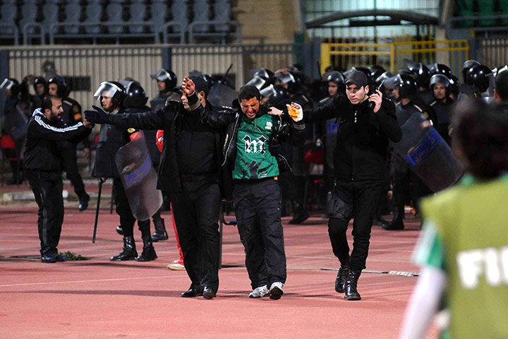 Port Said clashes: An injured fan is led away during clashes between supporters at Port Said