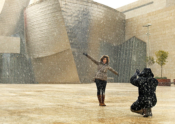 Europe weather: A couple at Guggenheim museum during a snowy day in Bilbao, Spain