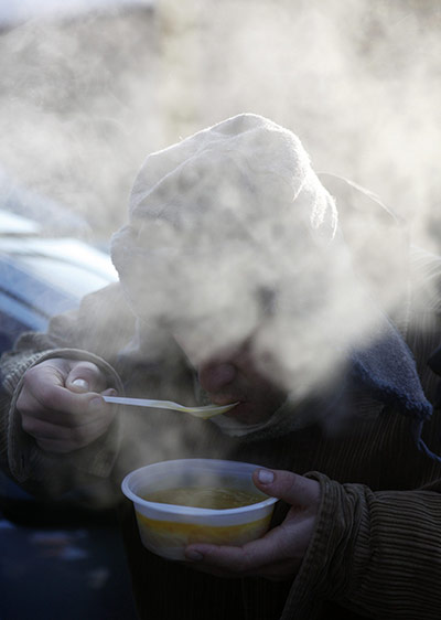 Europe weather: A man eats soup at Russian Orthodox church to help homeless people
