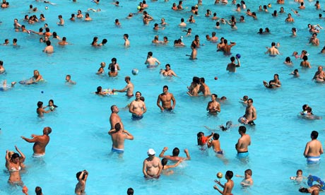 People crowd a swimming pool