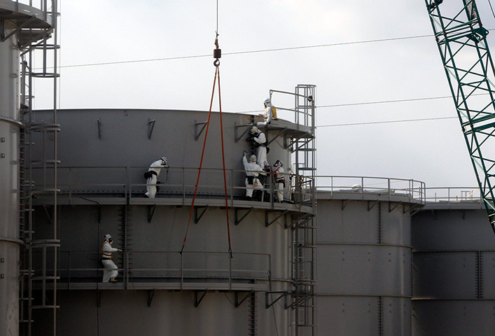inside Fukushima: workers masks construct water tanks at the powerstation
