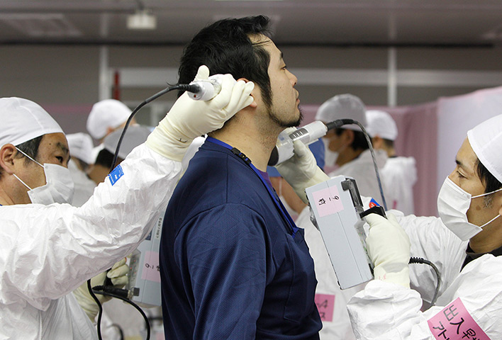 inside Fukushima: a worker is given a radiation screening