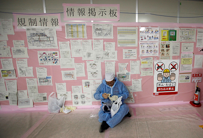 inside Fukushima: a worker in front of an information board