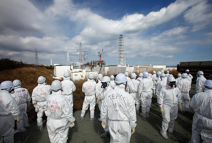 inside Fukushima: members of the media wearing protective suits and masks