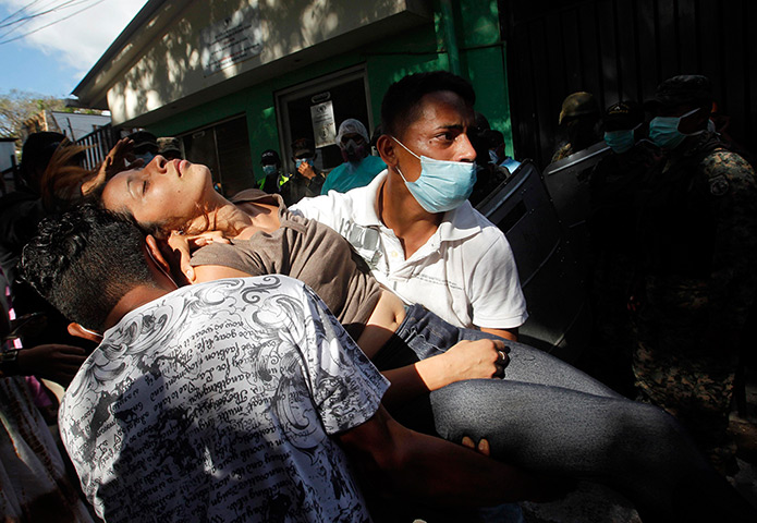 Honduras : A woman collapses as relatives of the victims clash with riot police