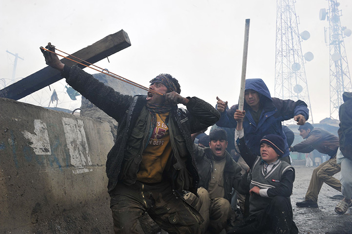Bagram protest: man aims a slingshot
