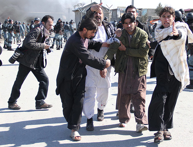 'Qur'an burning' Bagram: Afghans help an injured man