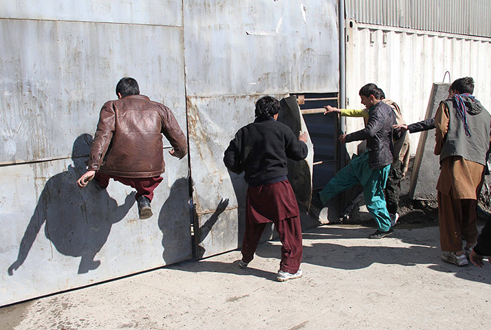 'Qur'an burning' Bagram: Afghans jump on gates of a fortified building believed to be a NATO base