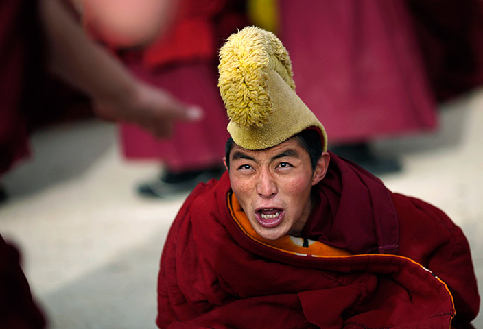 24 hours in pictures: A monk reacts during a debate as part of Tibetan New Year celebration