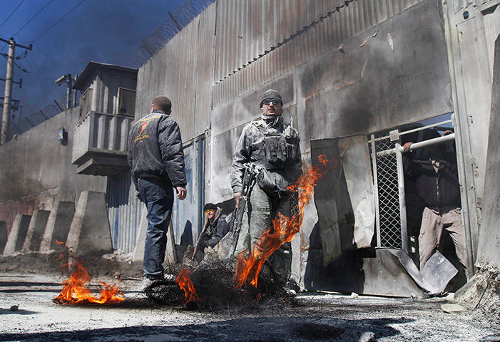 24 hours in pictures: Security guards stand by burning tyre in Kabul