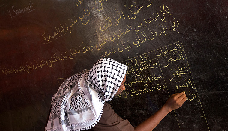 24 hours in pictures: A teacher writes in Arabic on a blackboard, Somalia