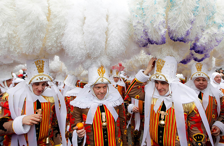 24 hours in pictures: The Gilles of Binche hold oranges as they parade during the carnival