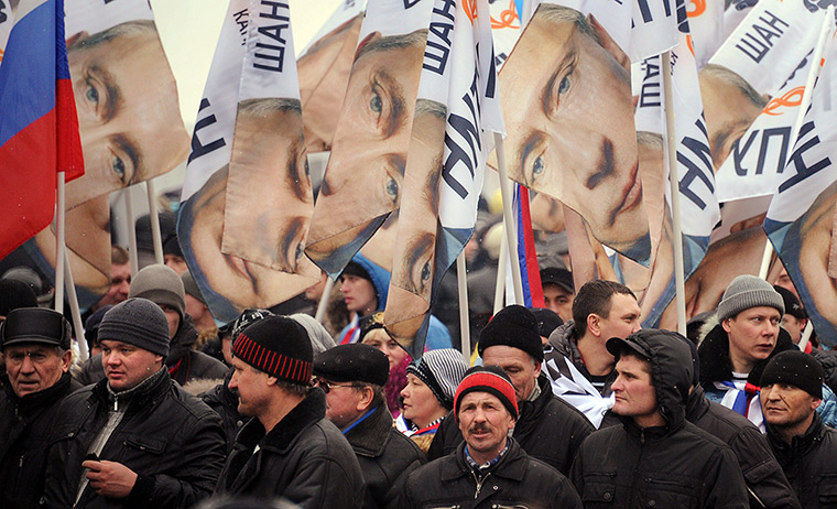 Putin presidential rally: Supporters of Vladimir Putin carry portraits of him along the Moskva river