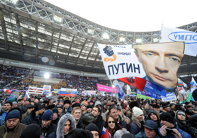 Putin presidential rally: Supporters Vladimir Putin wave flags at the Luzhniki stadium