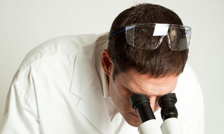 Scientist looking down a microscope