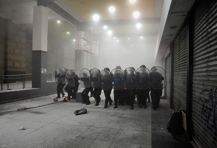 24 Hours: Anti-riot policemen walk towards protesters at a train station in Argentina