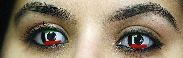 24 Hours: A woman wears contact lenses in the colours of her national flag in Kuwait