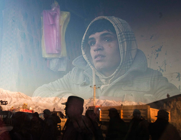 24 Hours: An Afghan boy who works at a bakery watches a protest in Kabul