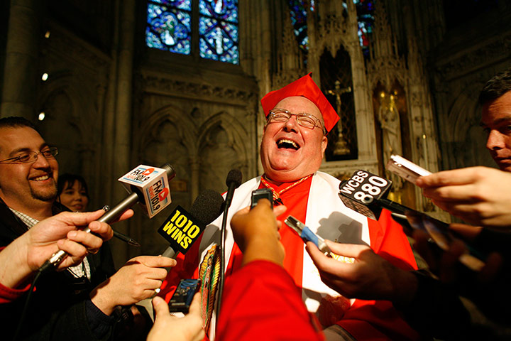 24hours: Cardinal Timothy Dolan laughs with reporters after holding a prayer service