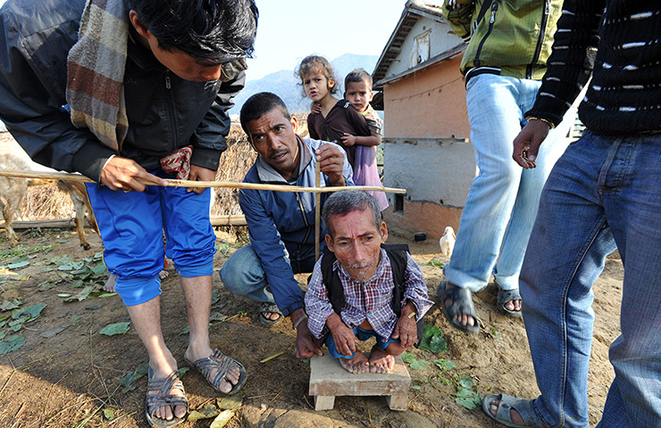 World's shortest man: Dangi, at 56 centimetres in height, stands as villagers measure him