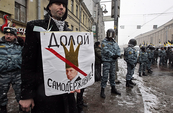 Anti-Putin protests: A man holds a poster depicting Putin wearing a crown