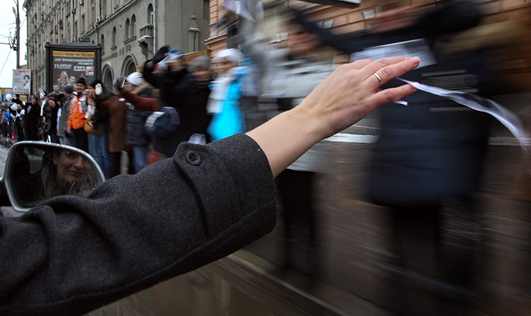 Anti-Putin protests: A woman waves a white ribbon at people standing along the Garden ring road
