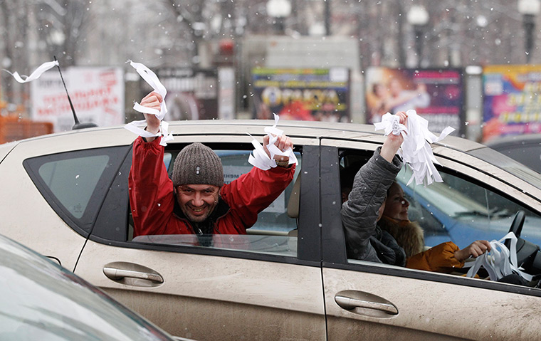 Anti-Putin protests: People hold white ribbons out of a car window