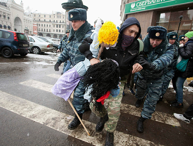Anti-Putin protests: Police officers detain a protester during The White Ring demonstration