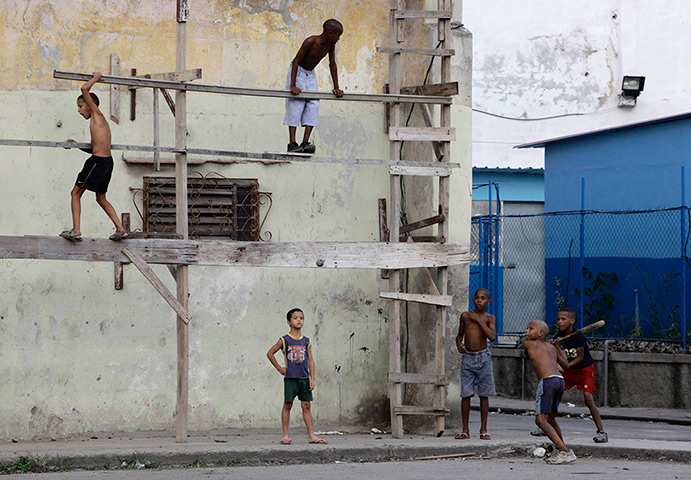 24 hours in pictures: Boys play baseball on a street in Havana