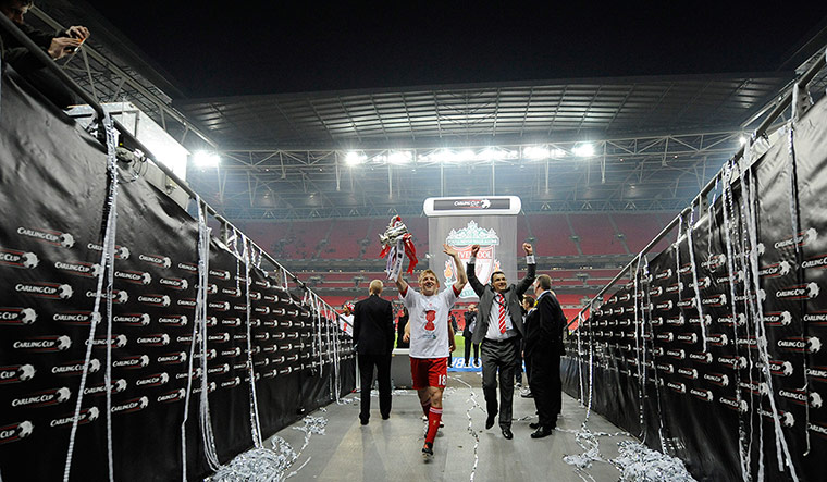 Carling Cup: Dirk Kuyt carries the trophy back down the tunnel to cheers from fans
