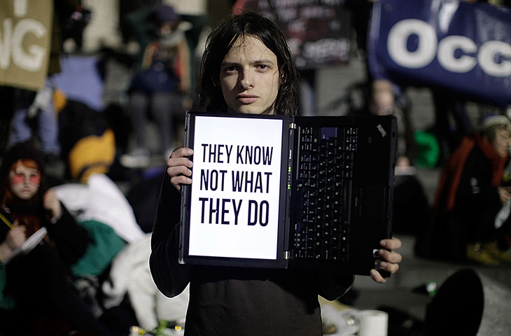 Occupy London eviction: Demonstrator hold up a laptop with slogan