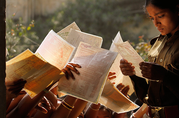 24 hours : Allahabad, India: A police officer checks forms of unemployed Indian women