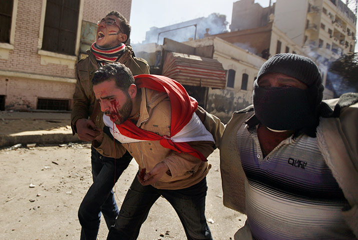 Egypt clashes: A wounded man is helped through the streets