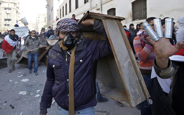 Egypt clashes: A man holds gas canisters