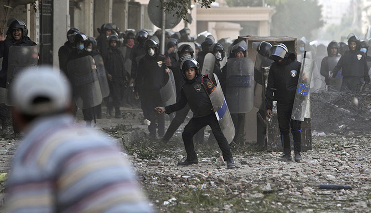 Egypt clashes: A protestor throws a stone at riot police