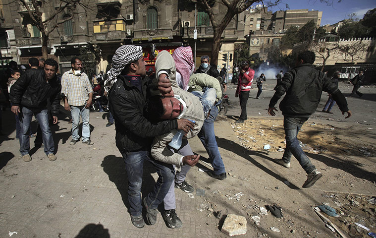 Egypt clashes: An injured man is carried through the streets