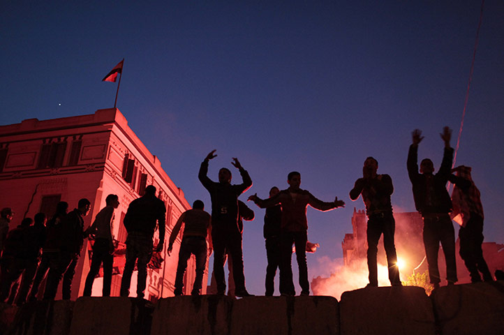 Egypt clashes: Egyptian protesters stand on a concrete wall built during previous clashes