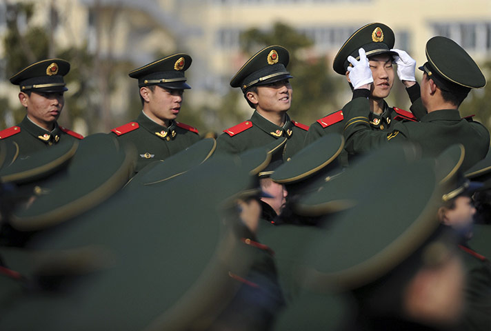 24 hours in pictures: An officer adjusts the cap of a paramilitary recruit in Nanjing