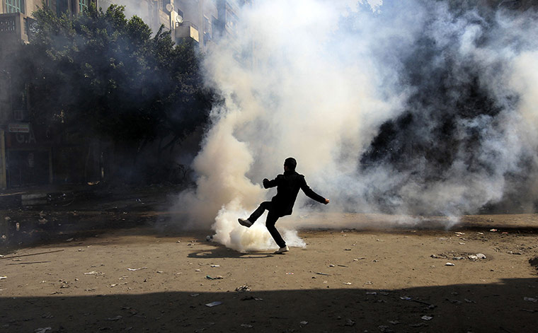 Egypt Protests: An Egyptian protester kicks a teargas canister