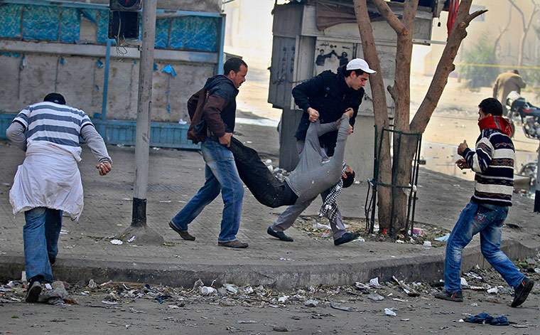 Egypt Protests: Egyptian protestors carry a wounded man during clashes with security forces