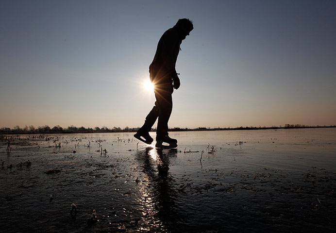 24 Hours: A man ice skates on the frozen fens in Welney, south east England