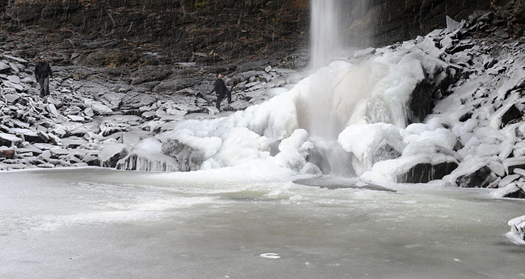 UK snow: A hiker looks at the spectacular frozen water fall at Hardraw, Yorkshire