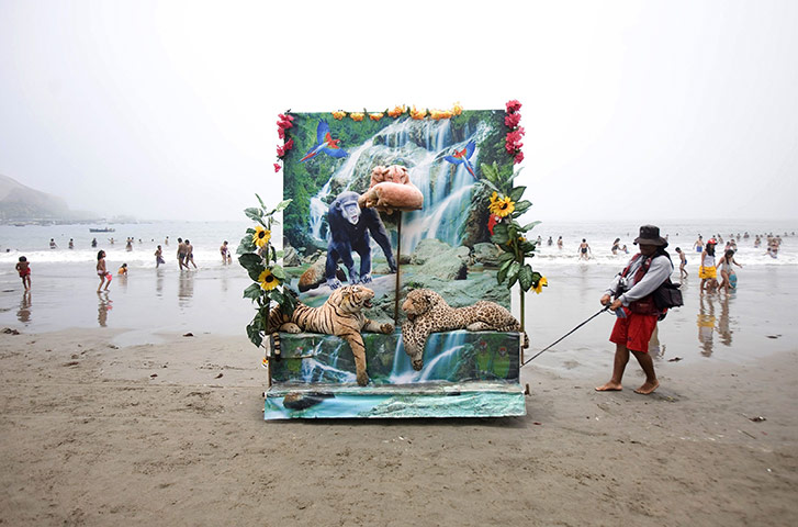 24 hours: Lima, Peru: A photographer pulls his backdrop at Agua Dulce beach 