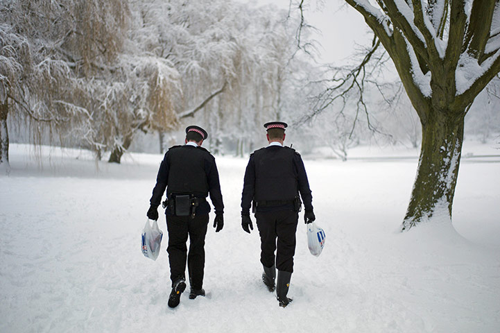 UK snow: Police officers walk through a snow-covered Hampstead Heath in London