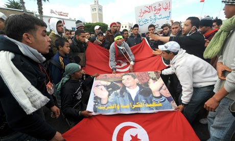 Inhabitants of Kasserine, Tunisia, walk with the Tunisian flag during clashes in January 2011