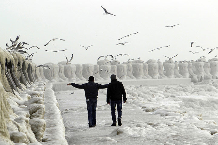 Europe weather: People stroll past the frozen shore in the Black Sea harbour of Constanta
